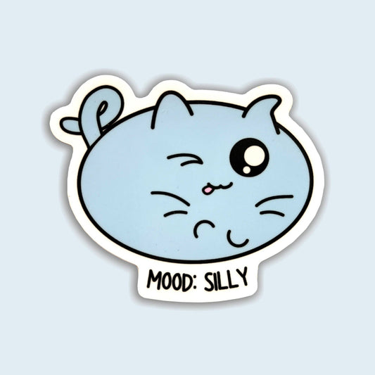 A die-cut sticker featuring a light blue cartoon cat face with one winking eye and the text 'MOOD: SILLY' below, shown on a pale blue background.