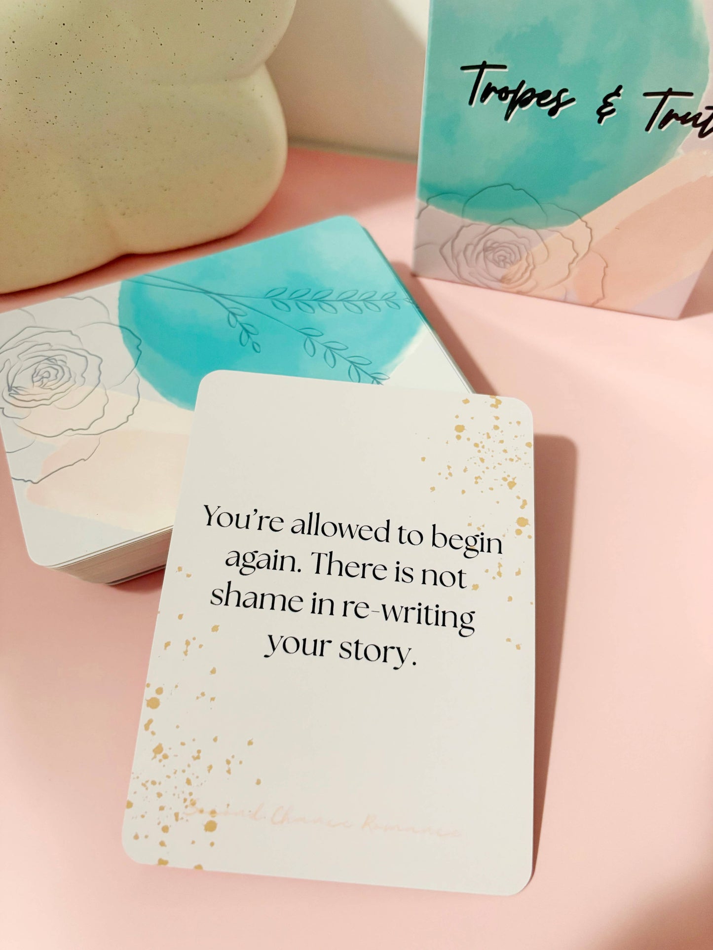 Motivational card with text on a pink surface, surrounded by other cards.