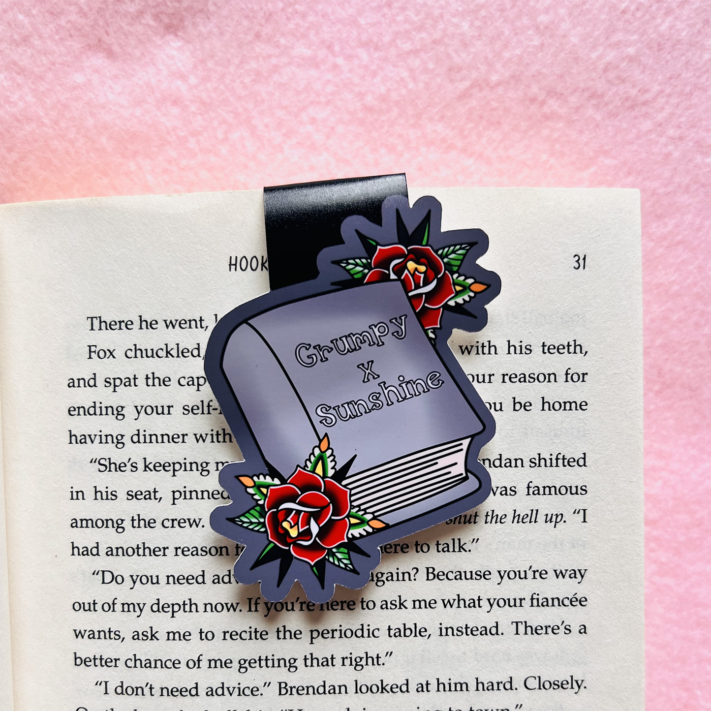 Bookmark with 'Grumpy X Sunshine' design on an open book with a pink background