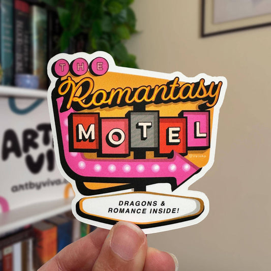 Sticker of 'The Romantasy Motel' with decorative text held in a hand.