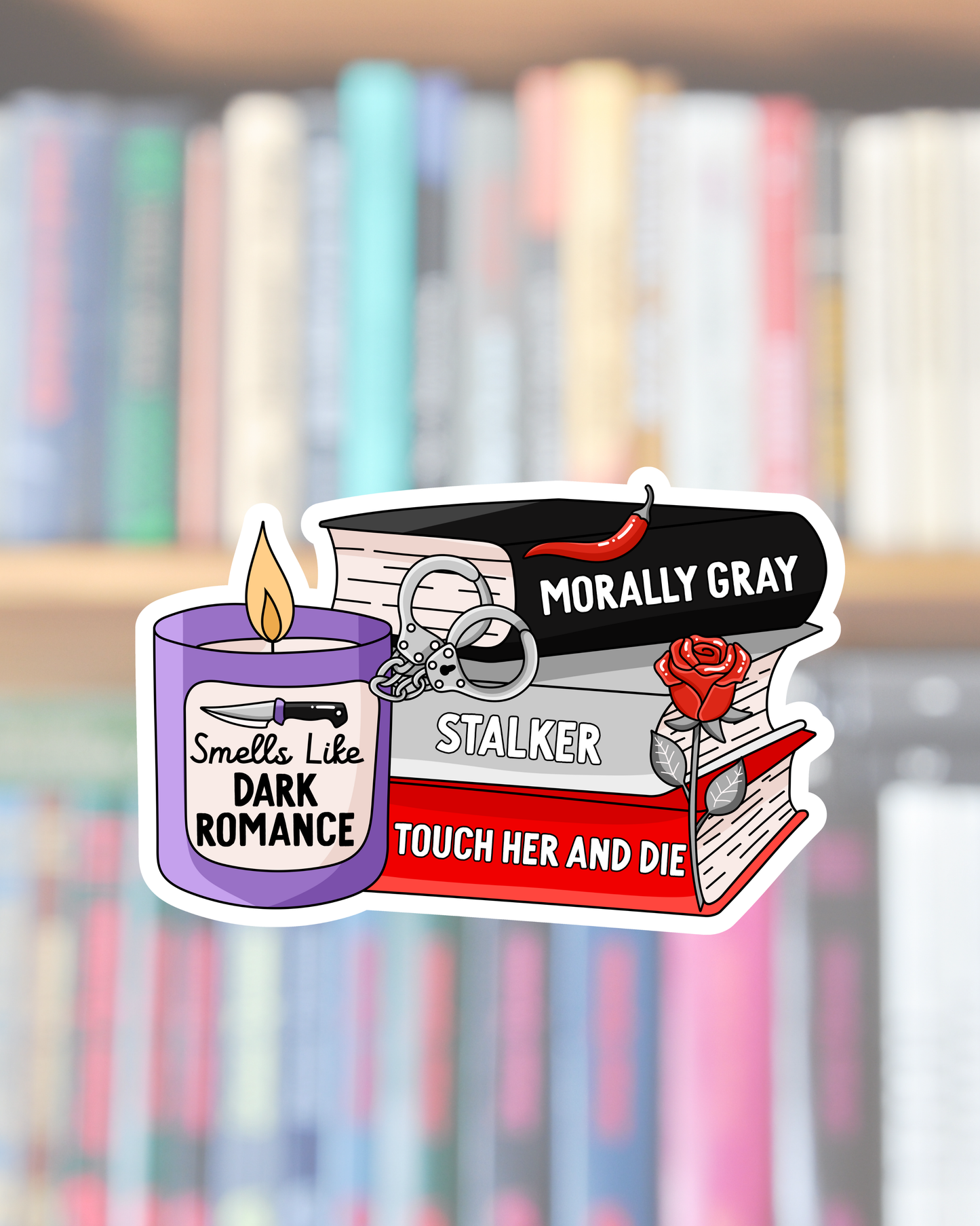 A die-cut sticker featuring book and candle-themed graphic elements with text including 'MORALLY GRAY', 'STALKER', 'TOUCH HER AND DIE', and 'Smells Like DARK ROMANCE', shown against a blurred bookshelf background.