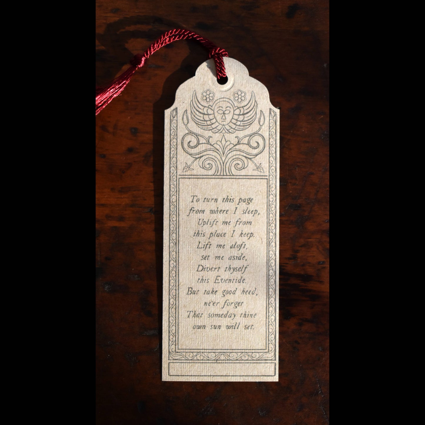 Decorative bookmark with text on a wooden surface