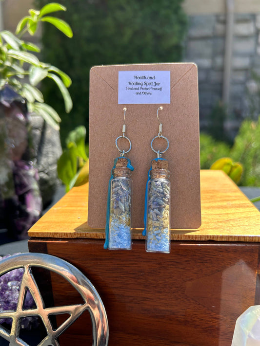 Pair of earrings on a display card with a pentacle symbol in the background