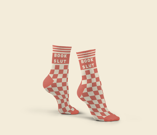 Red and white checkered socks with 'BOOK SLUT' text on a beige background
