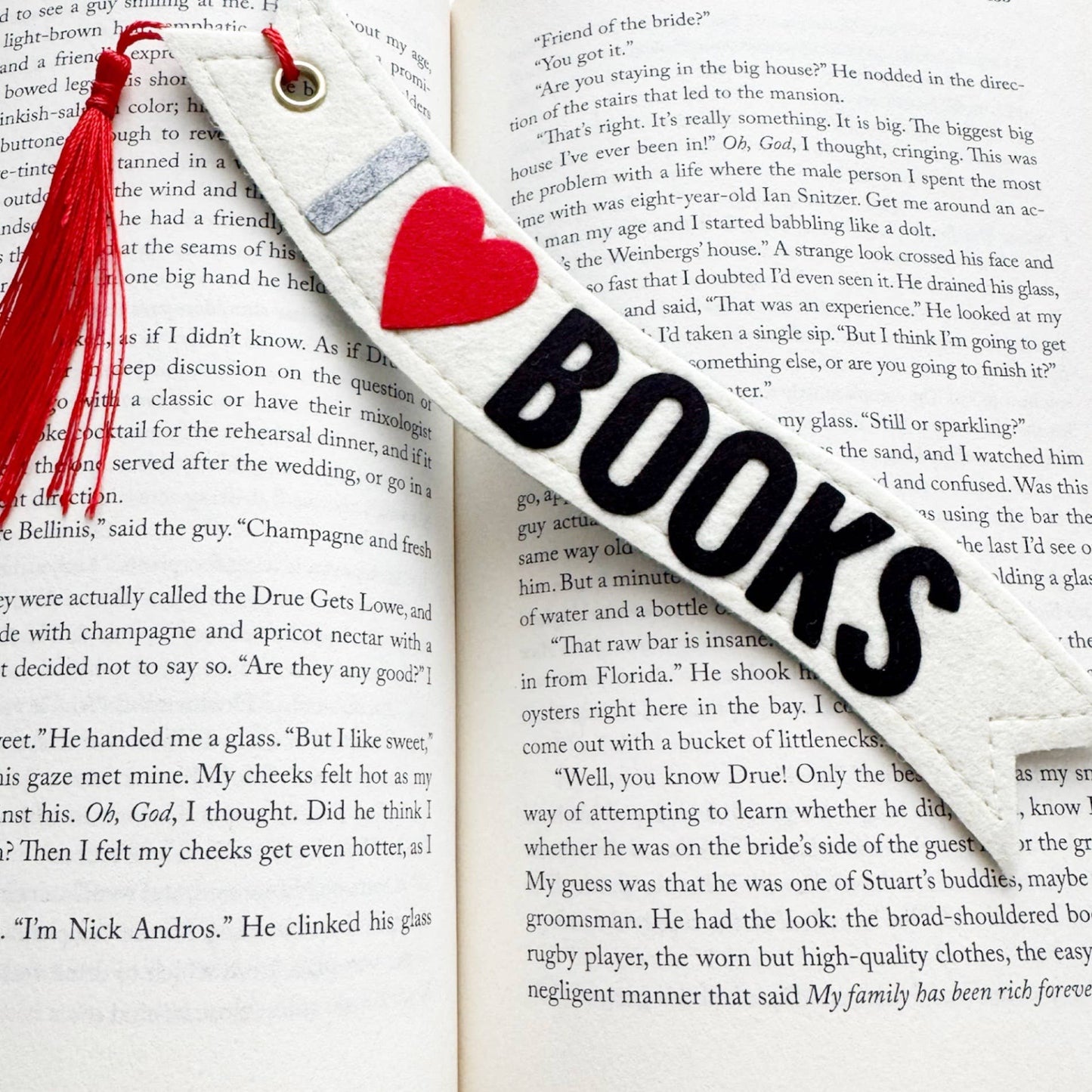 Bookmark with red heart and tassel on an open book