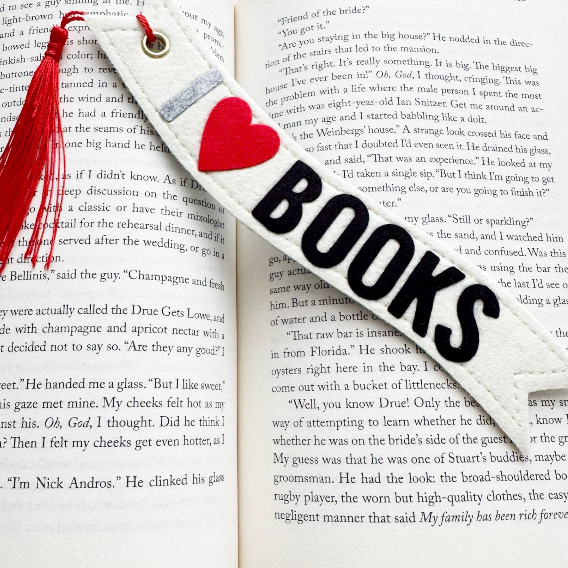Bookmark with red heart and tassel on an open book