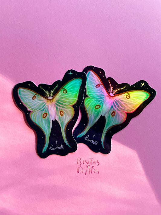 Two butterfly-shaped stickers with iridescent pastel wings on a black starry background, displayed on a pink surface with the text 'Besties Craft' below them.