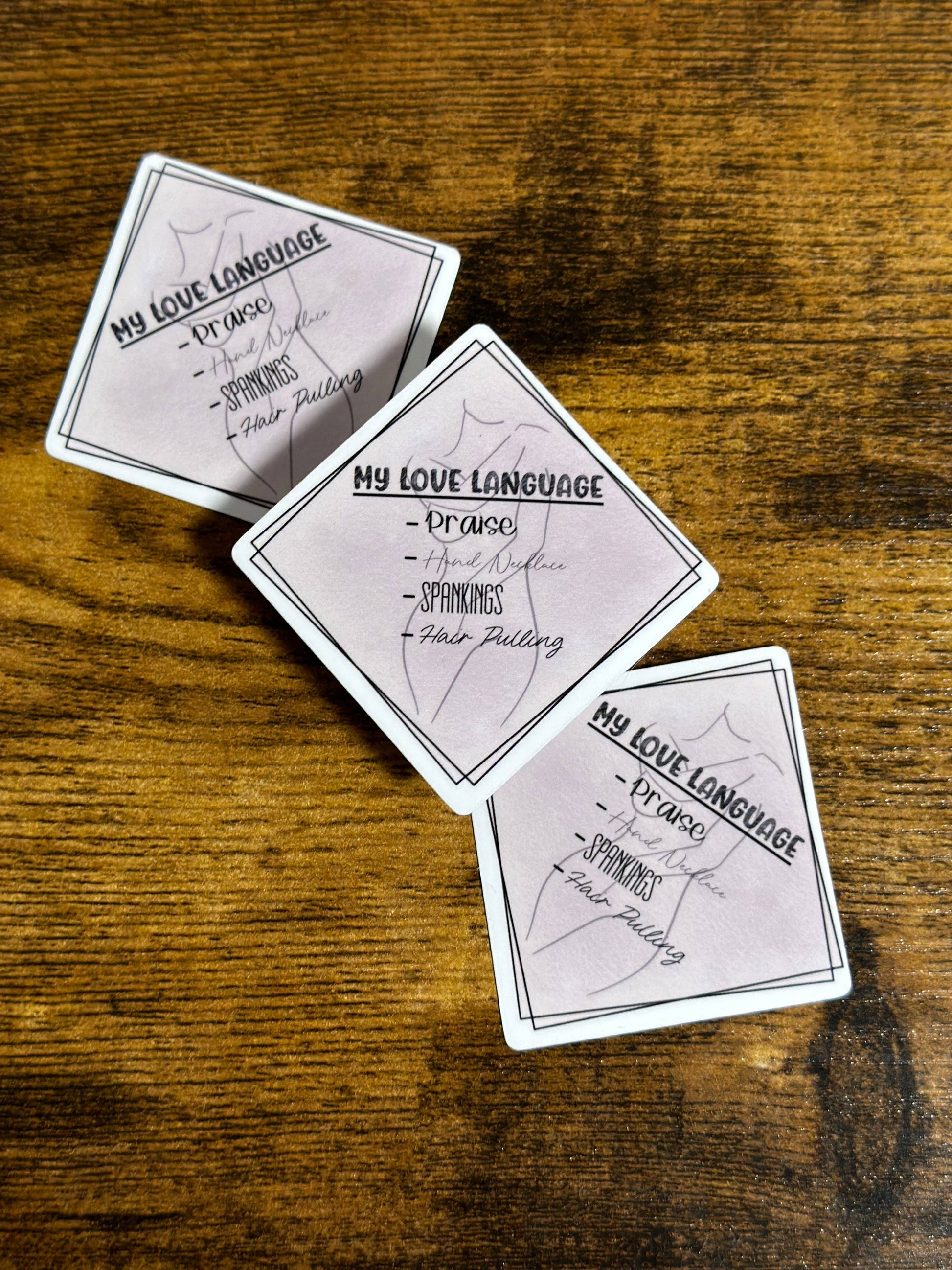 Three playing cards with text on a wooden surface