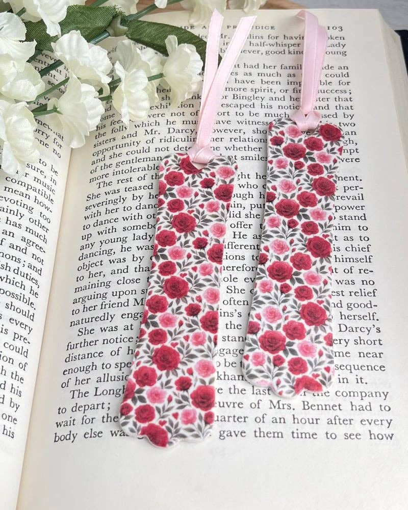 Floral bookmark on an open book with white flowers.
