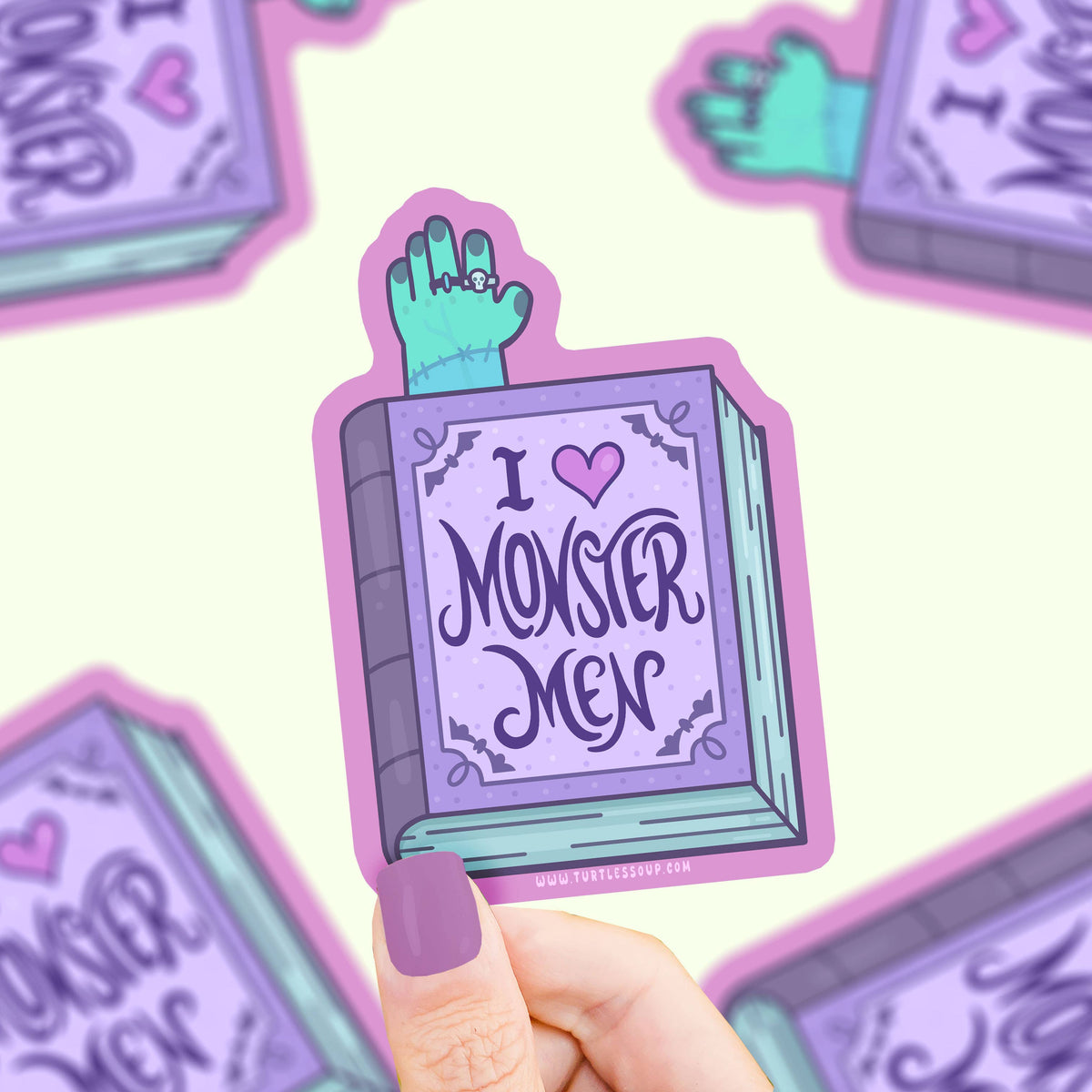 Sticker with 'I ❤️ Monster Men' design held by a hand on a light purple background.