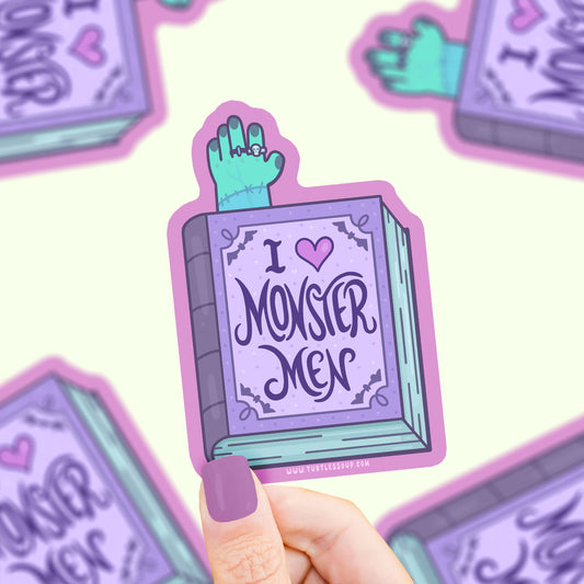 Sticker with 'I ❤️ Monster Men' design held by a hand on a light purple background.