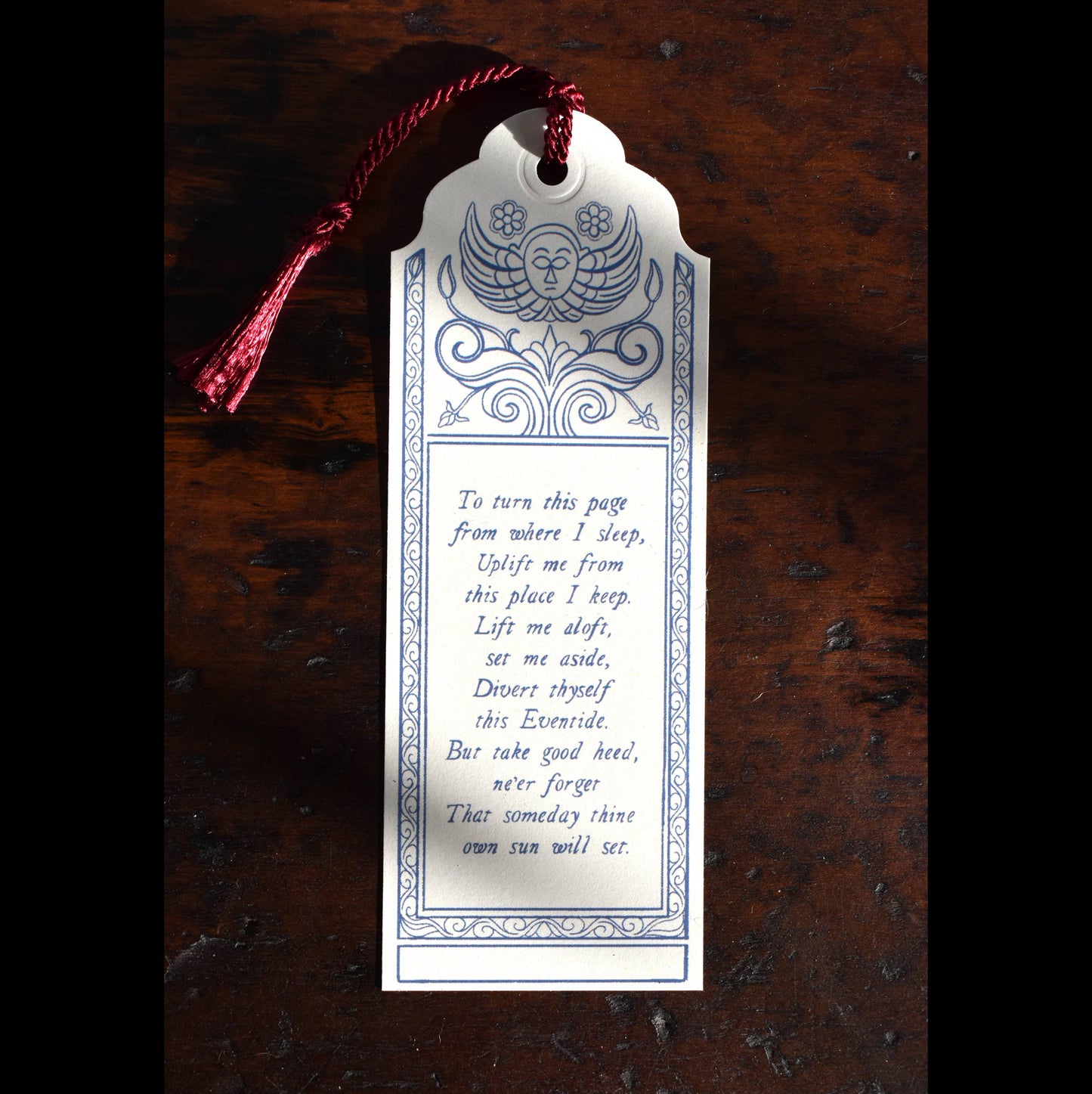 Decorative bookmark with text on a wooden surface