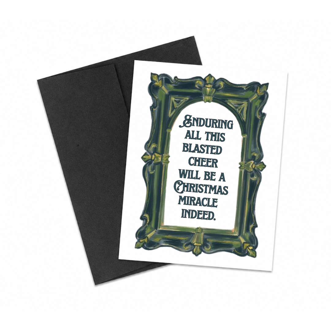 A Christmas greeting card with a black envelope, featuring a white card with a dark green ornate frame and the text 'ENDURING ALL THIS BLASTED CHEER WILL BE A CHRISTMAS MIRACLE INDEED.' on a white background.
