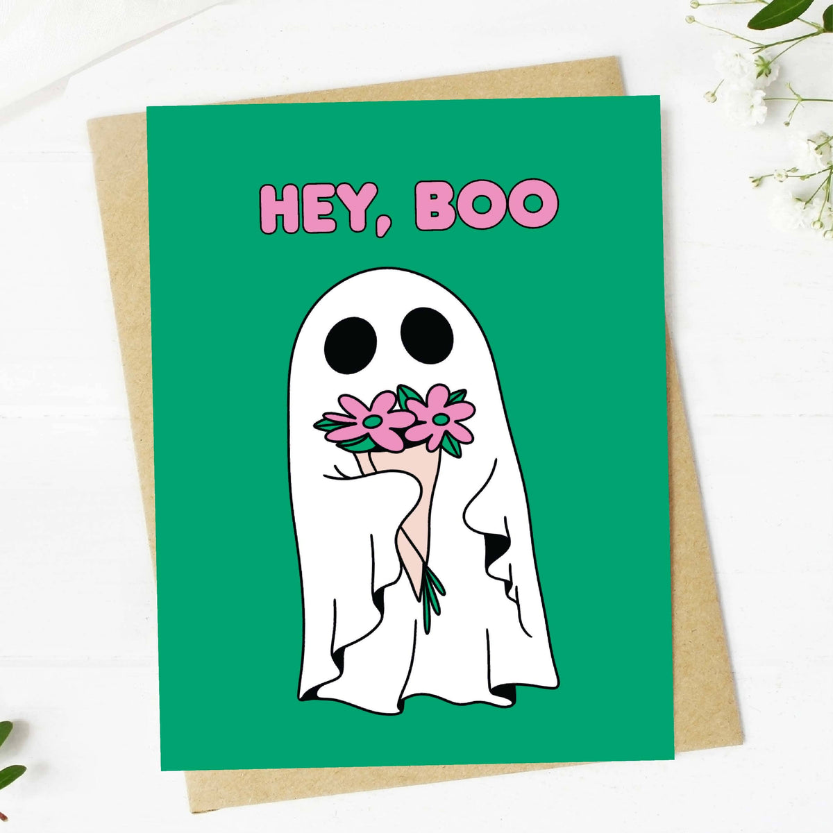 Greeting card with a ghost holding flowers and 'HEY, BOO' text on a green background