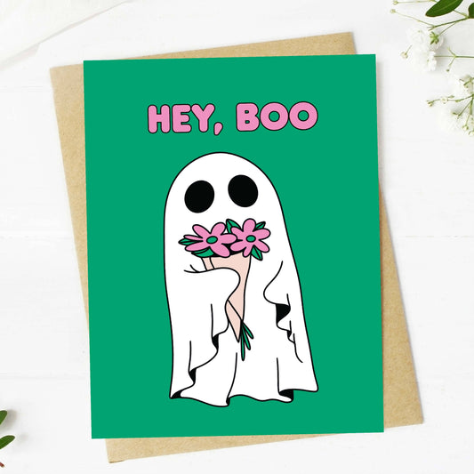 Greeting card with a ghost holding flowers and 'HEY, BOO' text on a green background