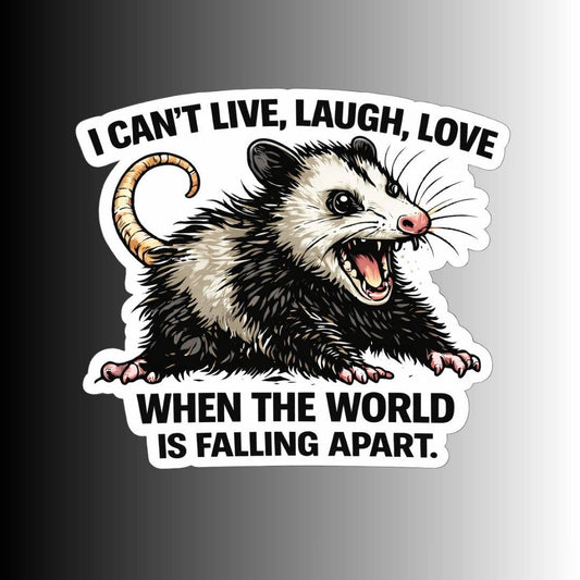 A die-cut sticker featuring a cartoon opossum with an open mouth and the text 'I CAN'T LIVE, LAUGH, LOVE WHEN THE WORLD IS FALLING APART.' on a black-to-white gradient background.