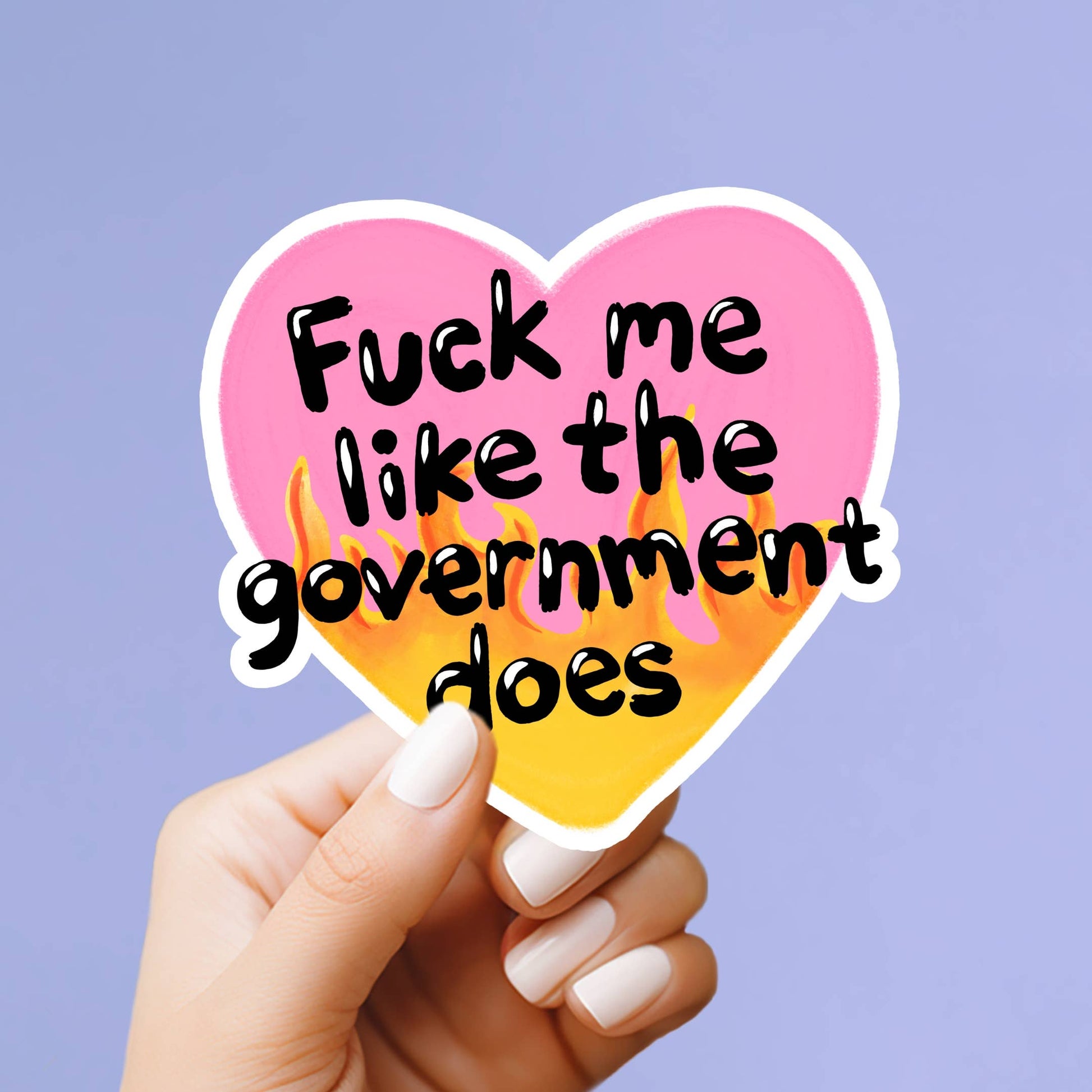 Heart-shaped sticker with offensive text held by a hand against a purple background