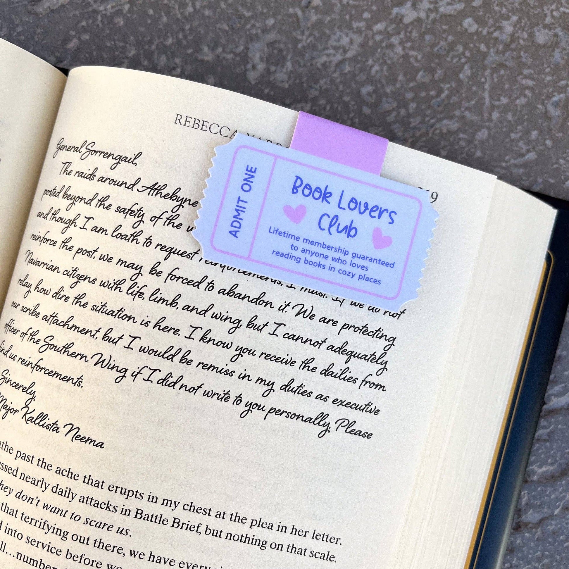 Book with a purple 'Book Lovers Club' bookmark on a textured surface