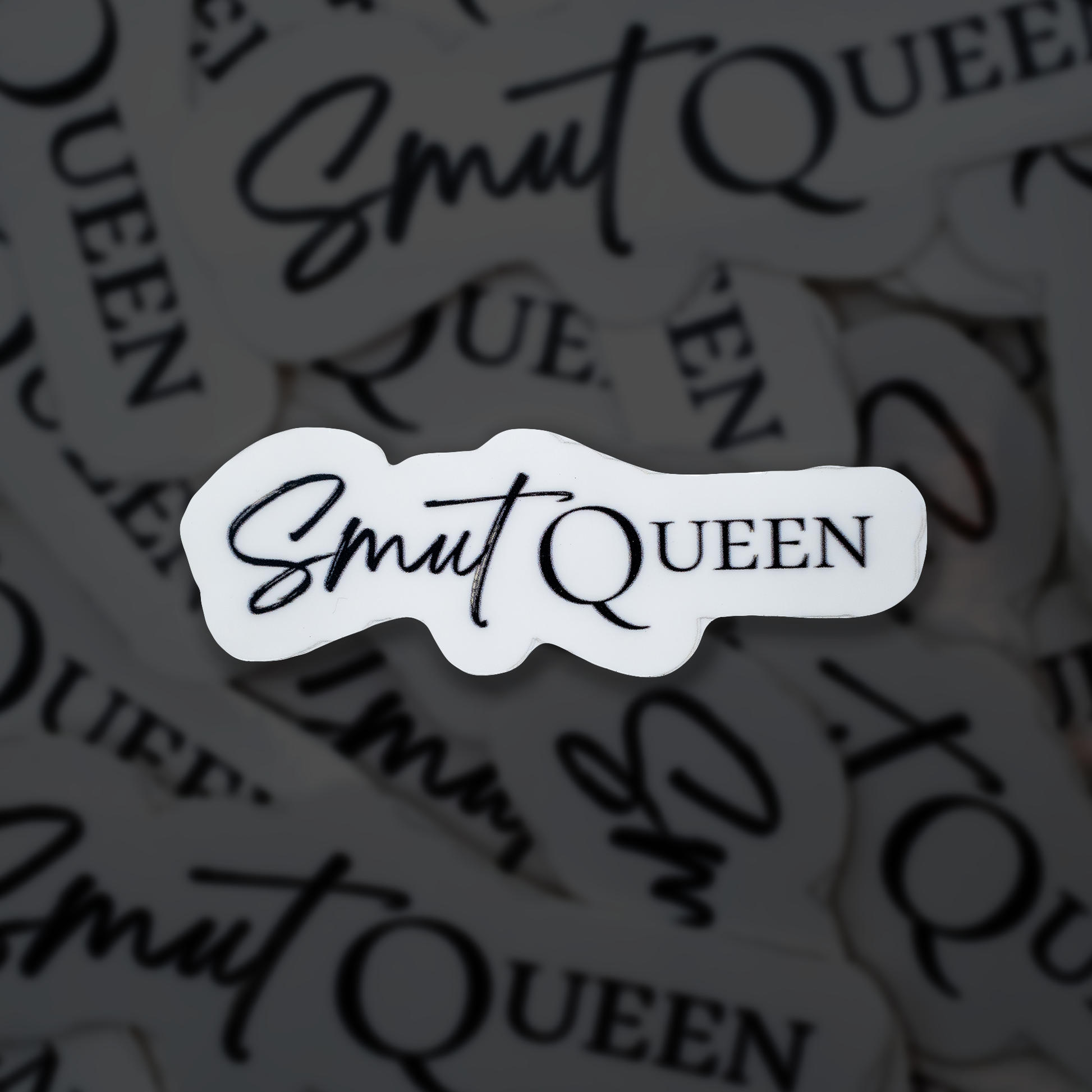 Sticker with 'Smut Queen' text on a blurred background of similar stickers.