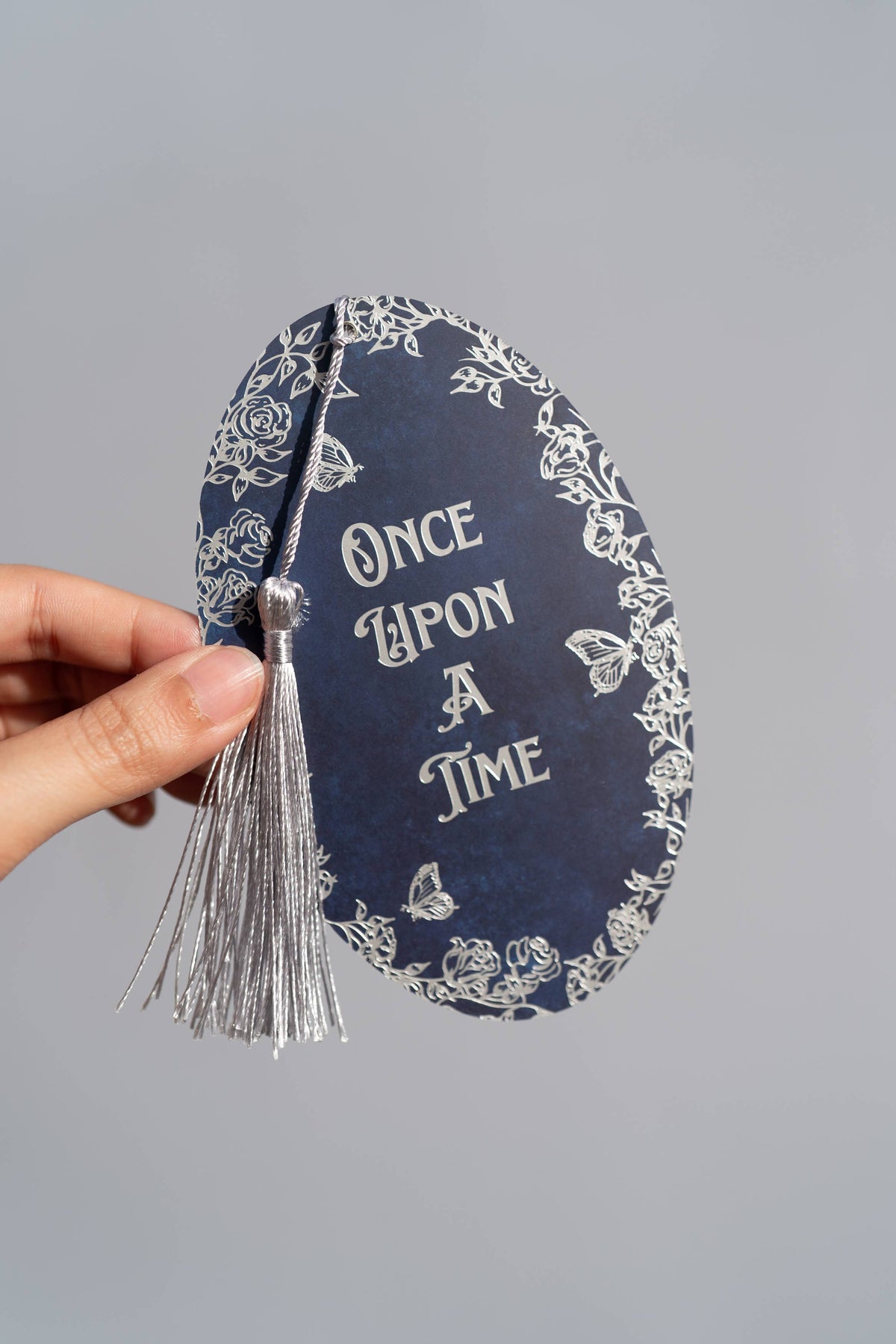 Decorative bookend with 'Once Upon A Time' text and tassel on a gray background