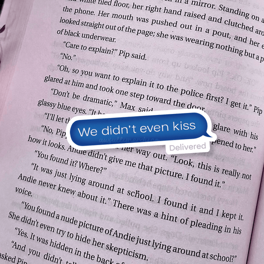 Text message bubble on a book page with text 'We didn't even kiss'.