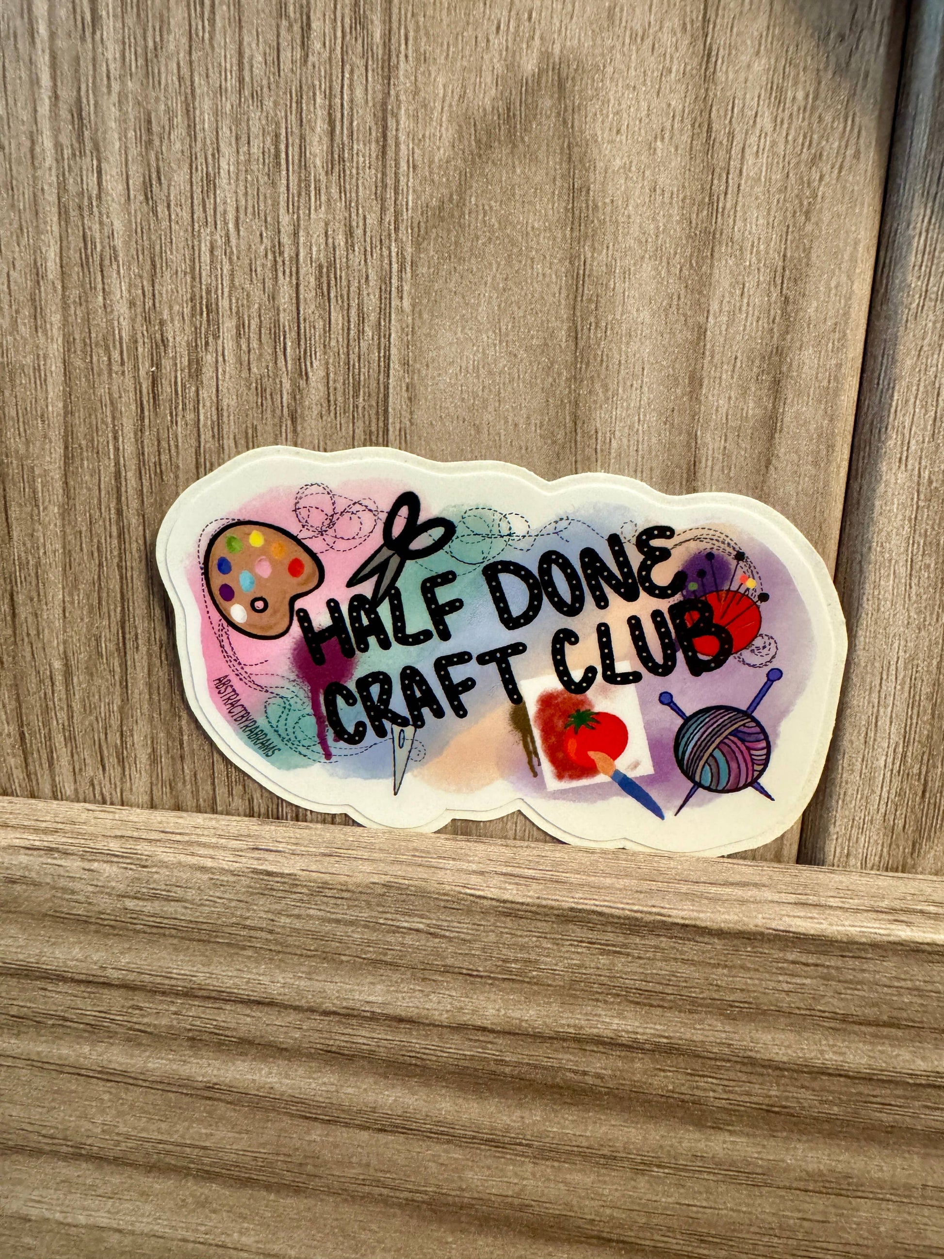 Sticker with 'Half Done Craft Club' text on a wooden surface