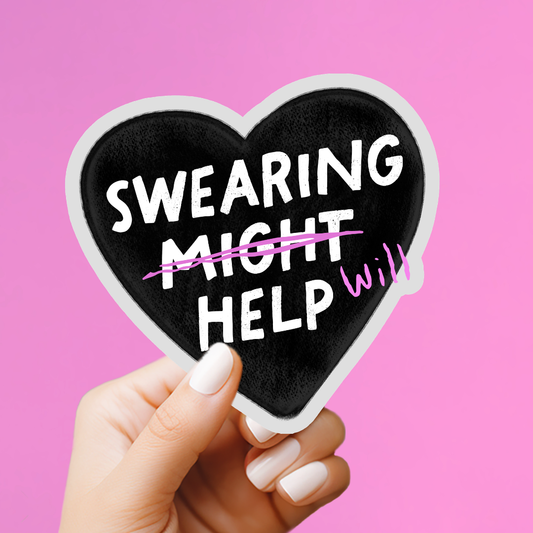 A hand with white manicured nails holds a heart-shaped black sticker or magnet with the phrase 'SWEARING MIGHT HELP' in white letters, crossed out with a pink scribble, against a solid pink background.