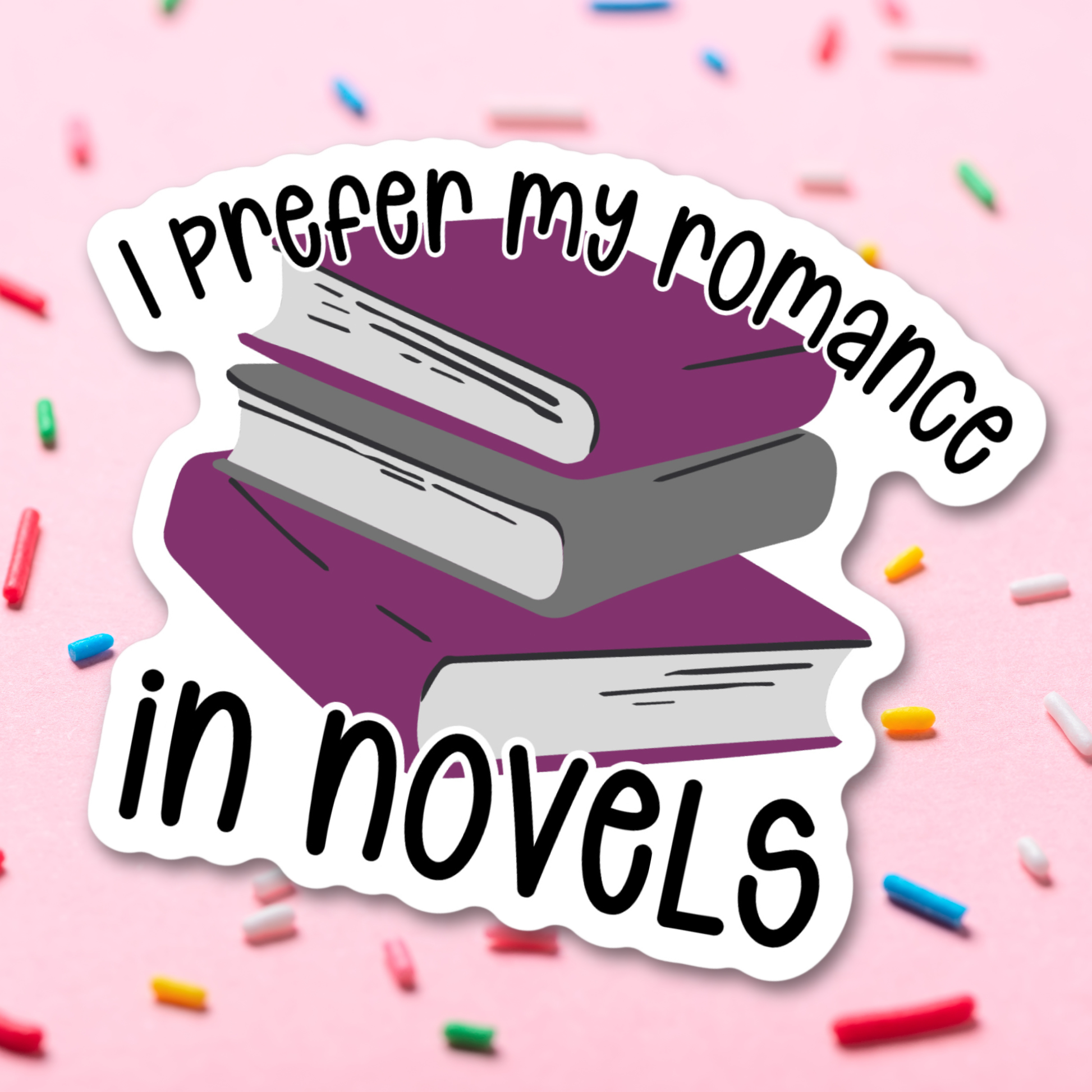 Sticker with books and text 'I prefer my romance in novels' on a pink background with colorful sprinkles.
