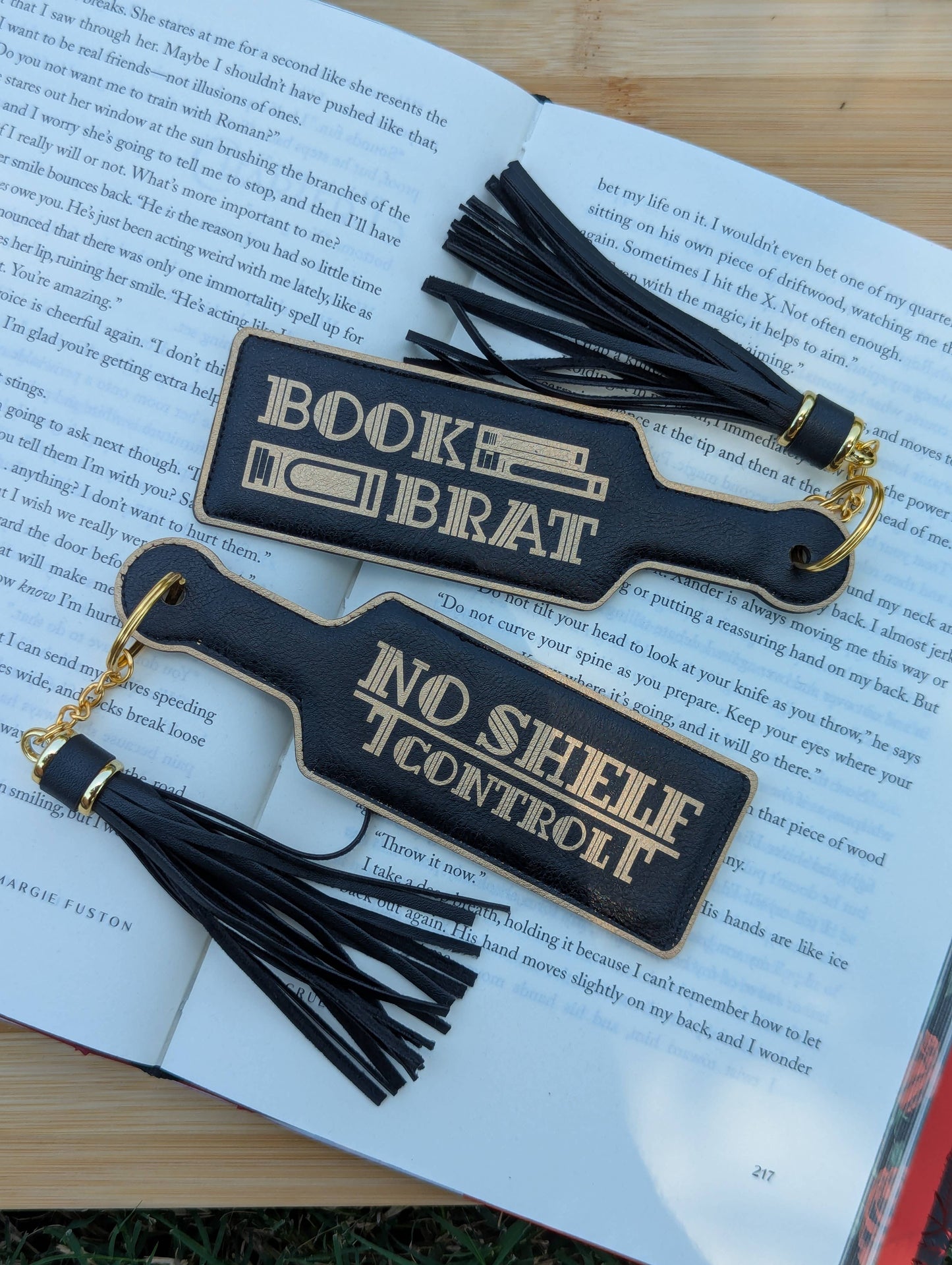 Two black leather bookmarks with tassels on an open book.