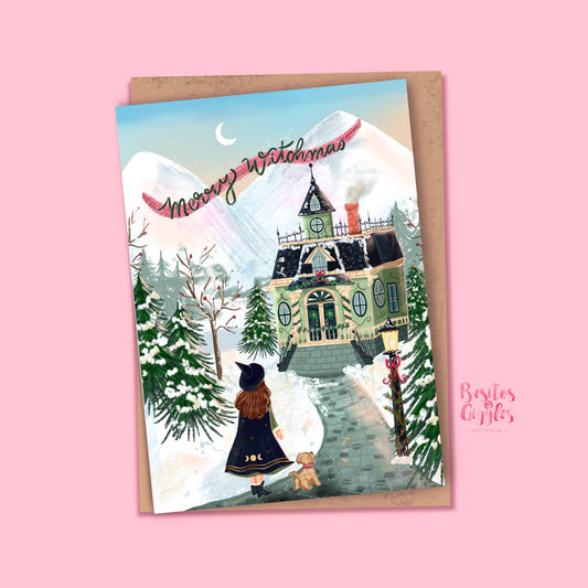A festive illustrated holiday card reading 'Merry Witchmas' with a snowy mountain scene, a witch in a black dress standing before a haunted house, and a small dog, shown on a kraft envelope against a pink background. A 'Besties Gifts' logo appears in the lower right.