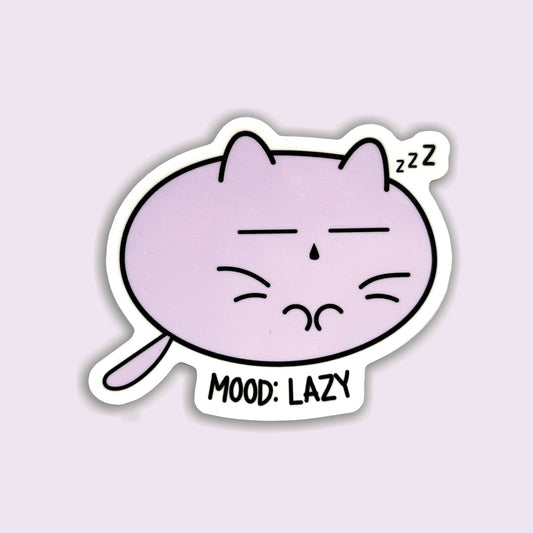 A die-cut sticker featuring a cartoon purple cat sleeping with closed eyes and the text 'MOOD: LAZY' and 'zzz', shown on a pale lavender background.