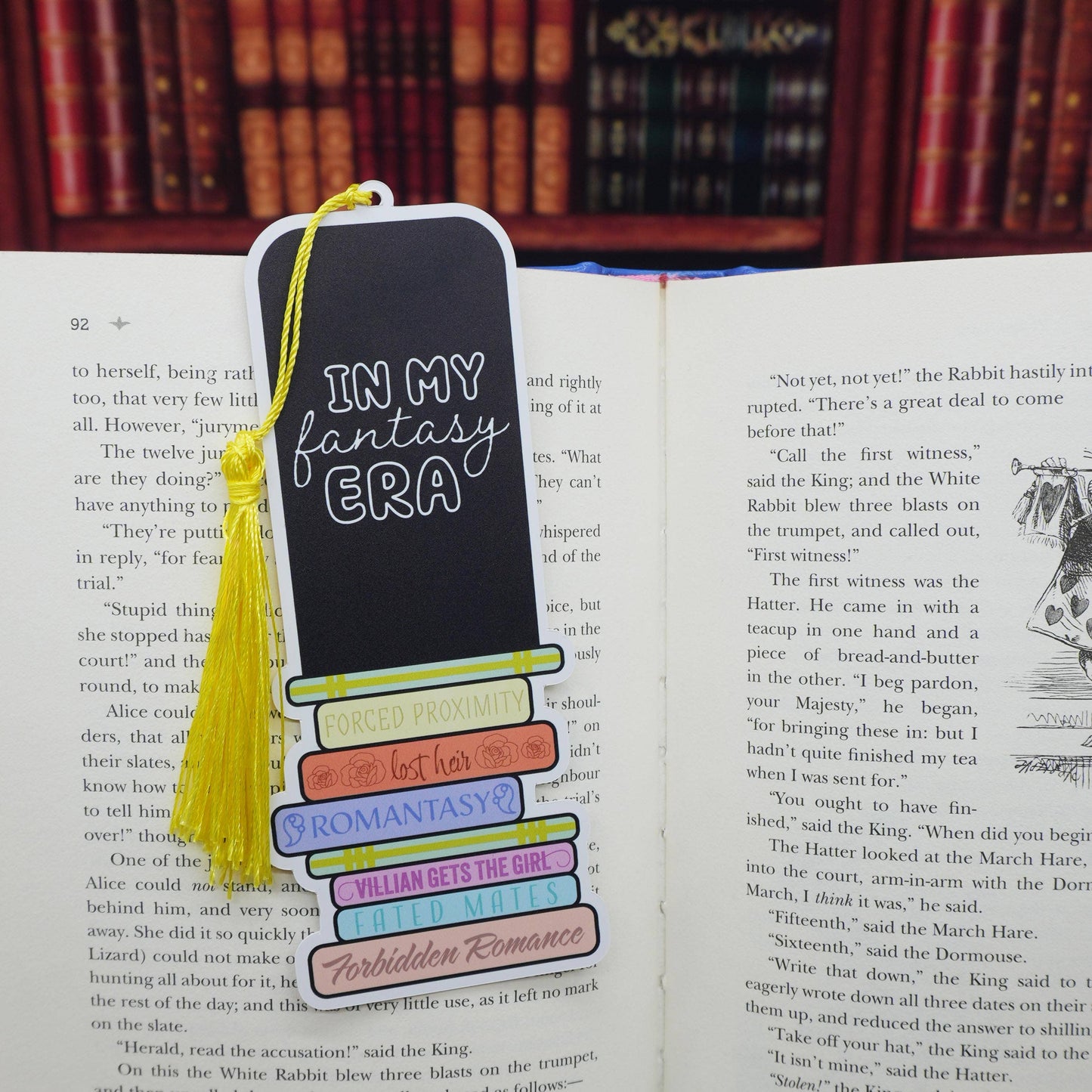 Bookmark with text 'In my fantasy era' on an open book with a blurred bookshelf background