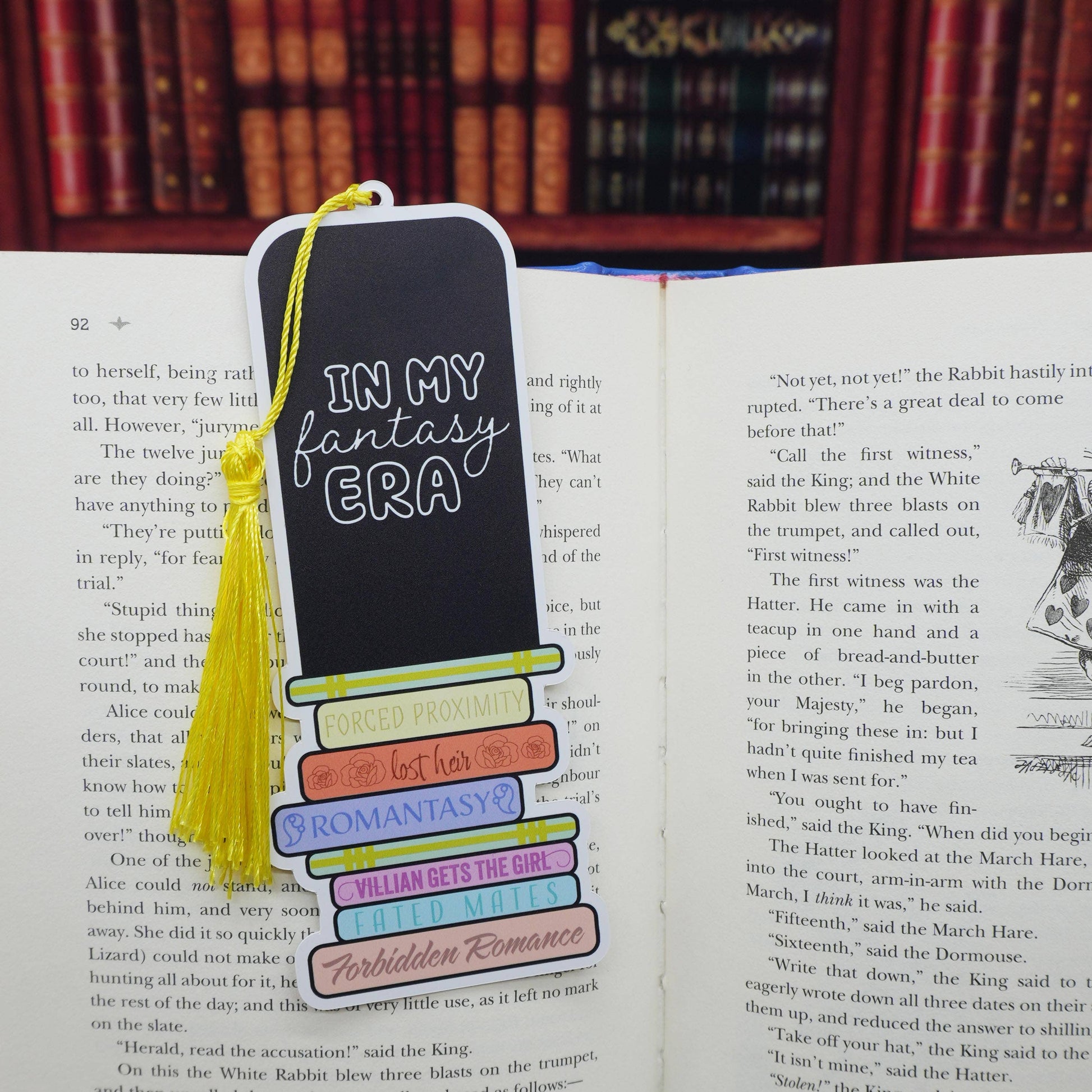 Bookmark with text 'In my fantasy era' on an open book with a blurred bookshelf background