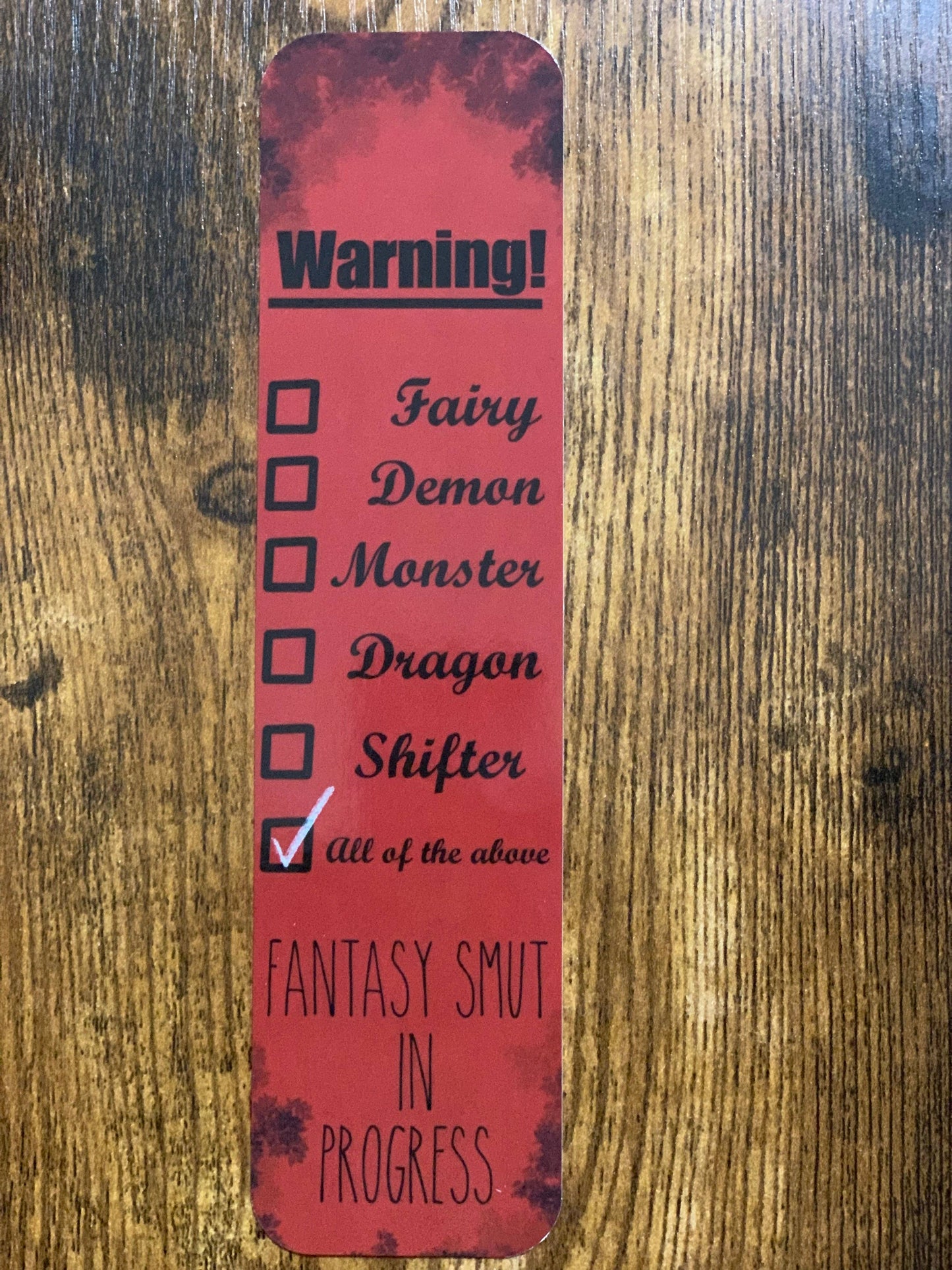 Red bookmark with text and checkboxes on a wooden surface