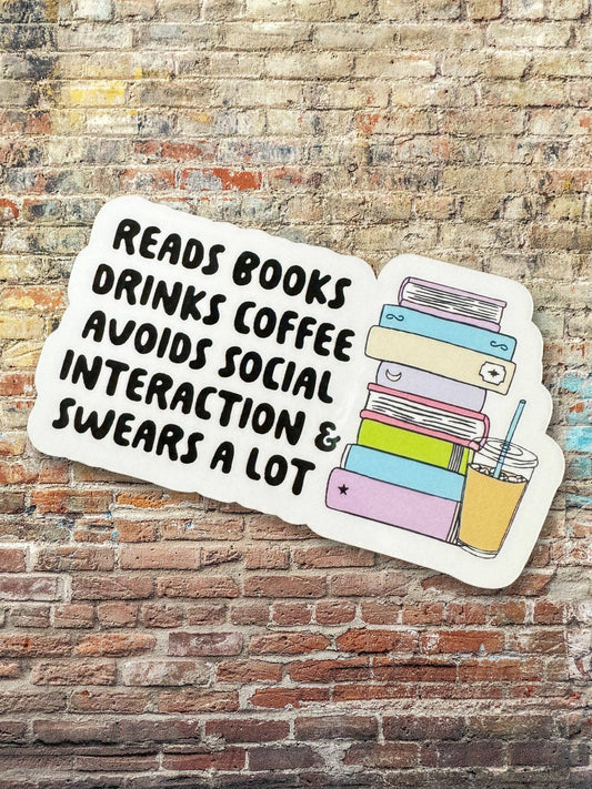 Sticker with text 'Reads books, drinks coffee, avoids social interaction & swears a lot' on a brick wall background