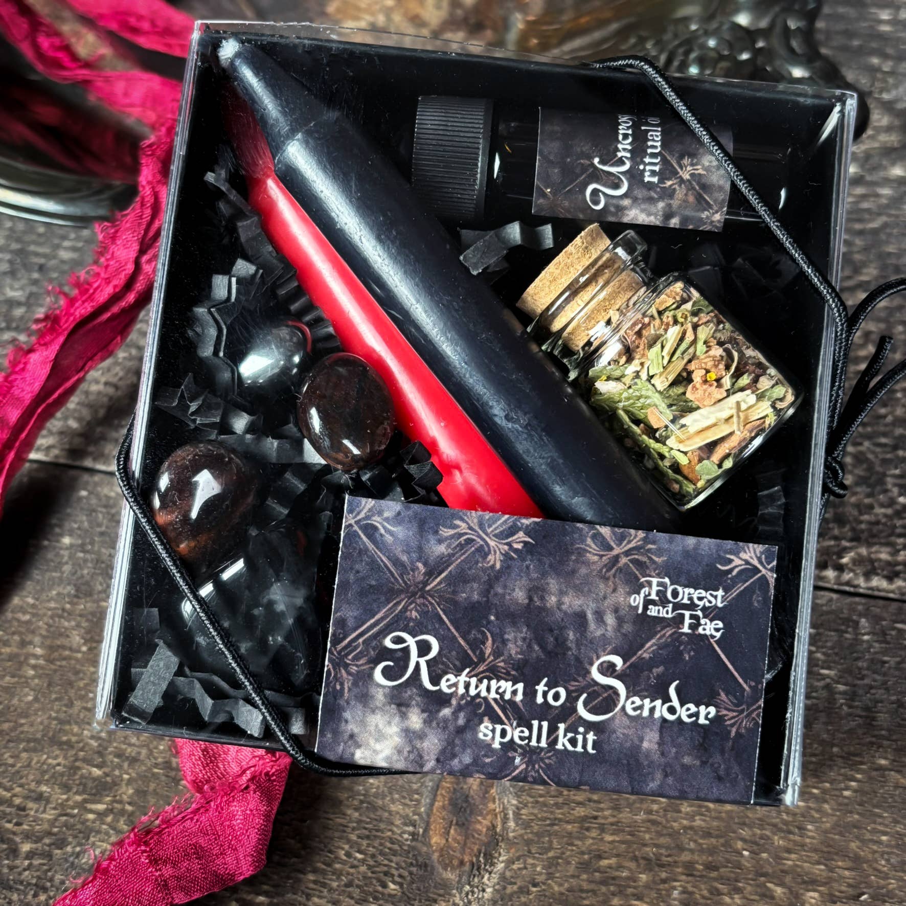 Spell kit labeled 'Return to Sender' with various items in a box on a wooden surface.