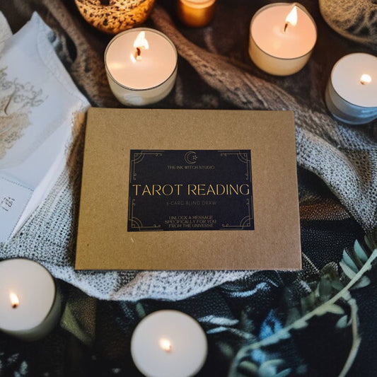Box labeled 'Tarot Reading' surrounded by lit candles on a textured surface