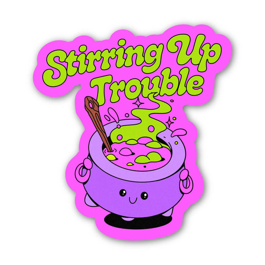 A die-cut sticker featuring a cartoon purple cauldron with green potion, a wooden spoon, and the text 'Stirring Up Trouble' in bright green bubble letters on a white background.
