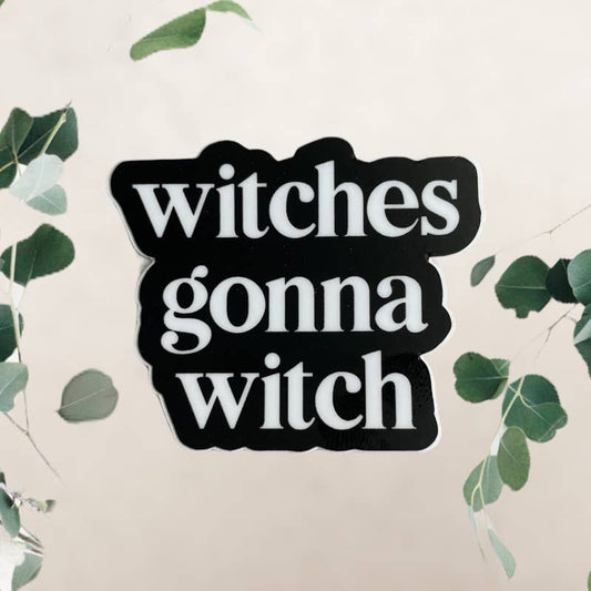Sticker with 'witches gonna witch' text on a light background with green leaves.