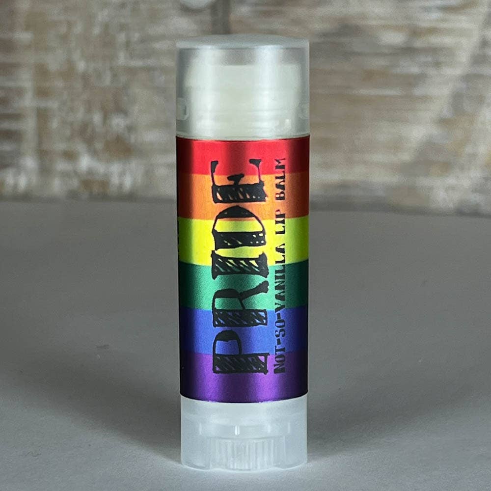 Lip balm with a rainbow label on a gray surface