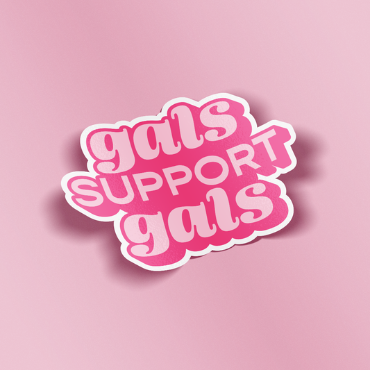 A die-cut sticker with the phrase 'gals SUPPORT gals' in pink bubble lettering with a white outline, shown on a solid pink background.