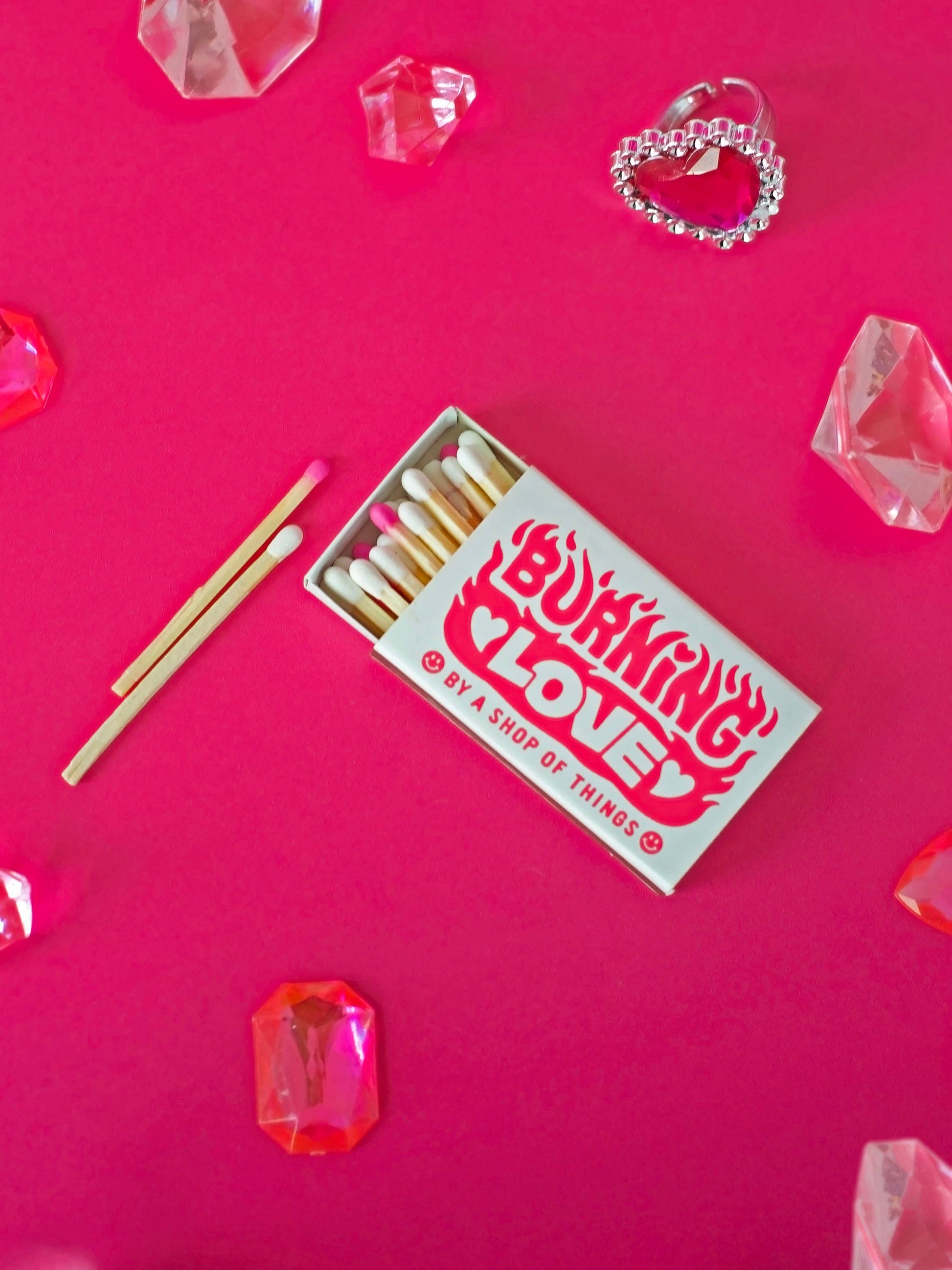 Matchbox with matches on a pink background with decorative elements