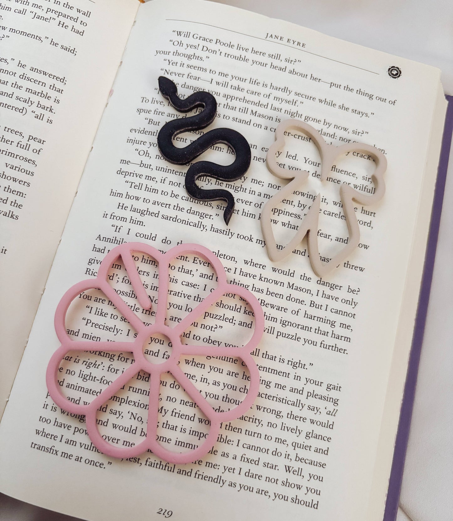 Black and pink snake-shaped rings on an open book
