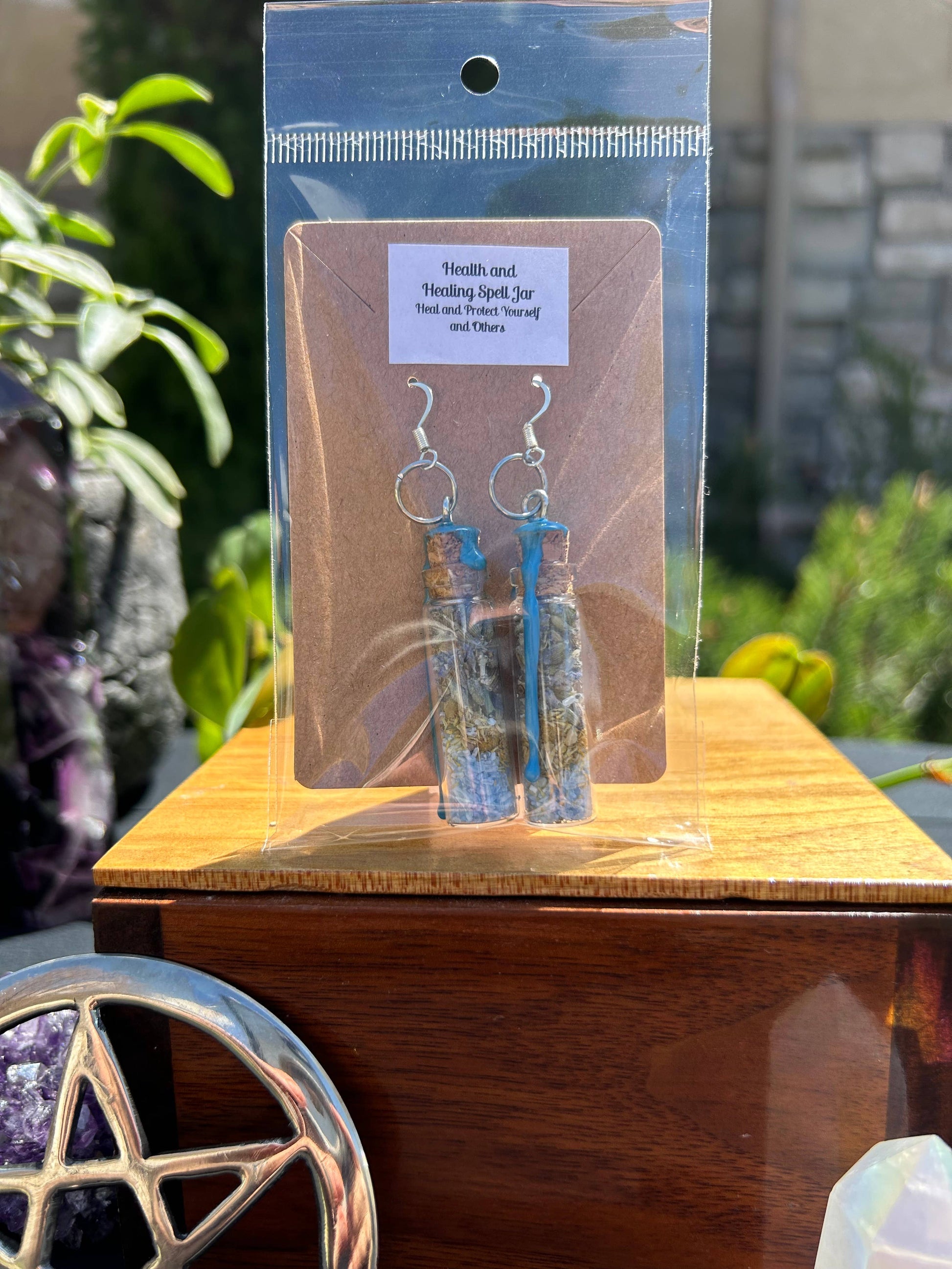 Blue and clear glass earrings on a wooden stand with a blurred background
