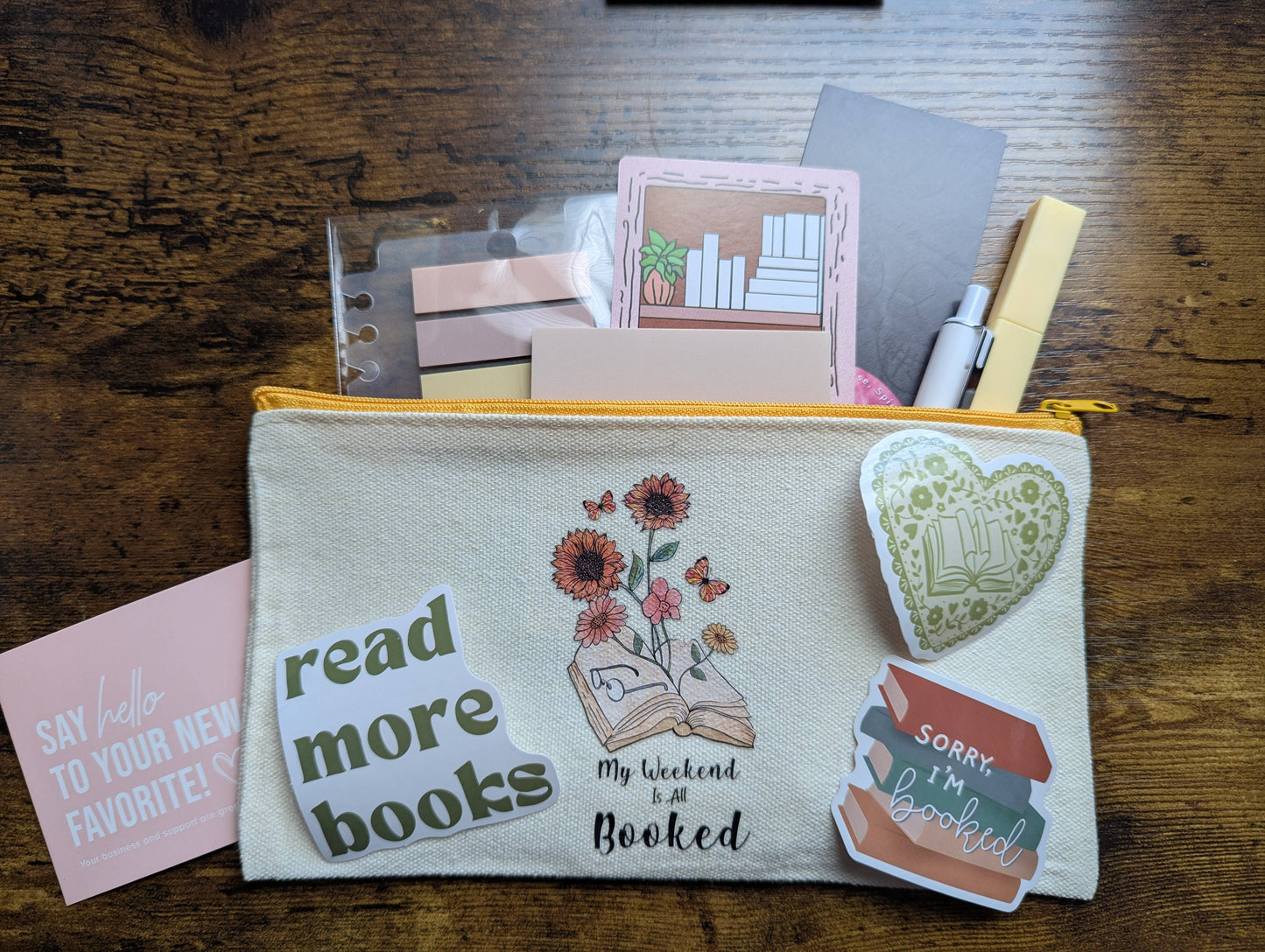Pouch with book-themed designs and text on a wooden surface