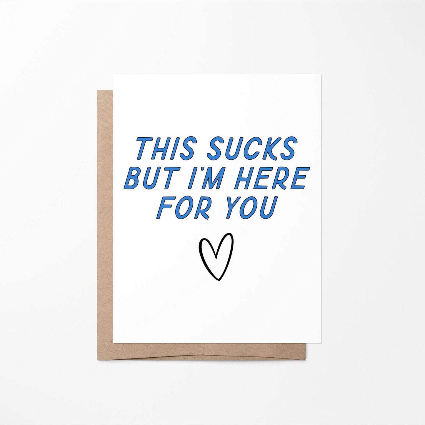 Card with blue text 'This sucks but I'm here for you' and a black heart on a white background