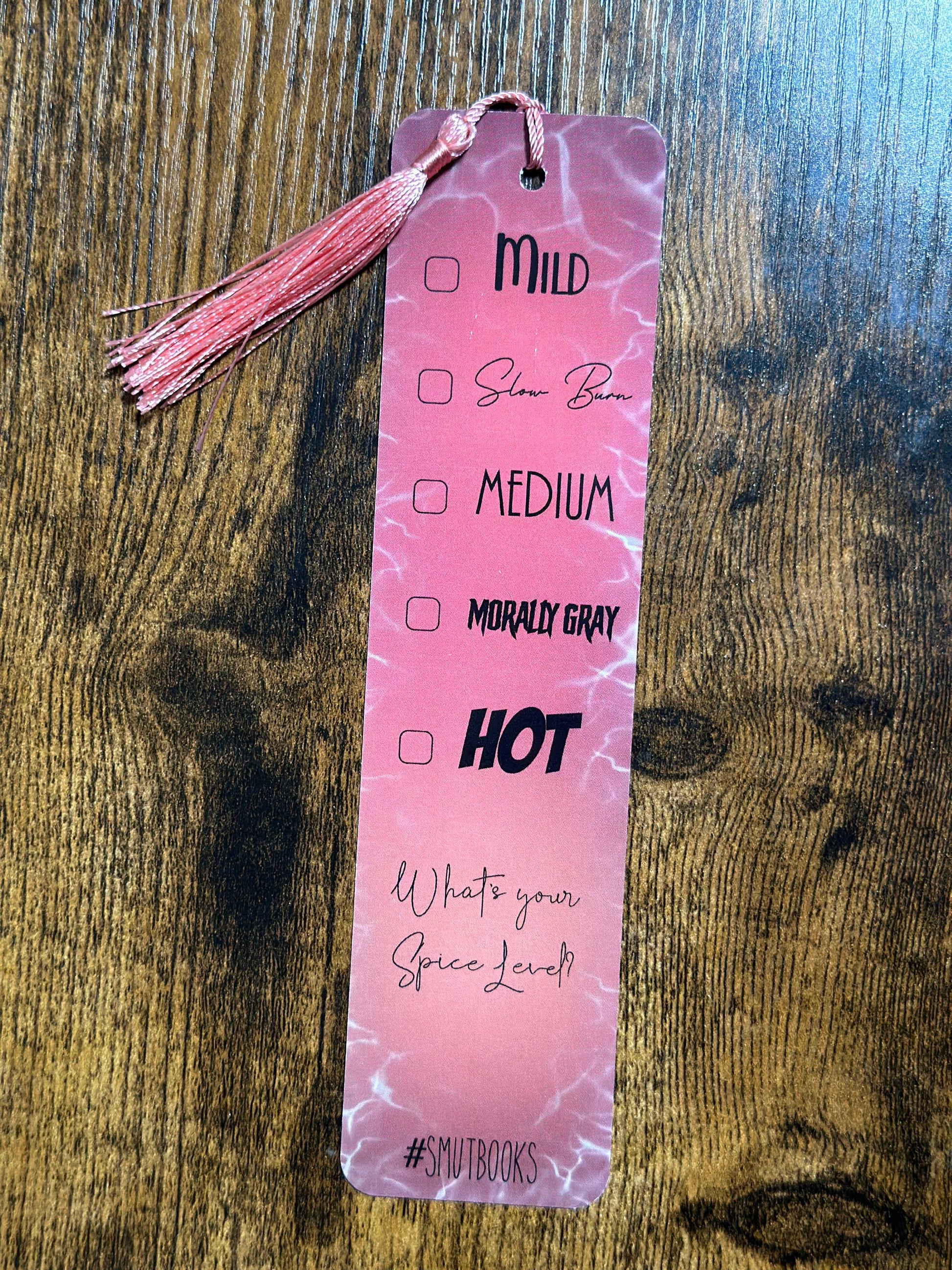 Pink bookmark with text and checkboxes on a wooden surface