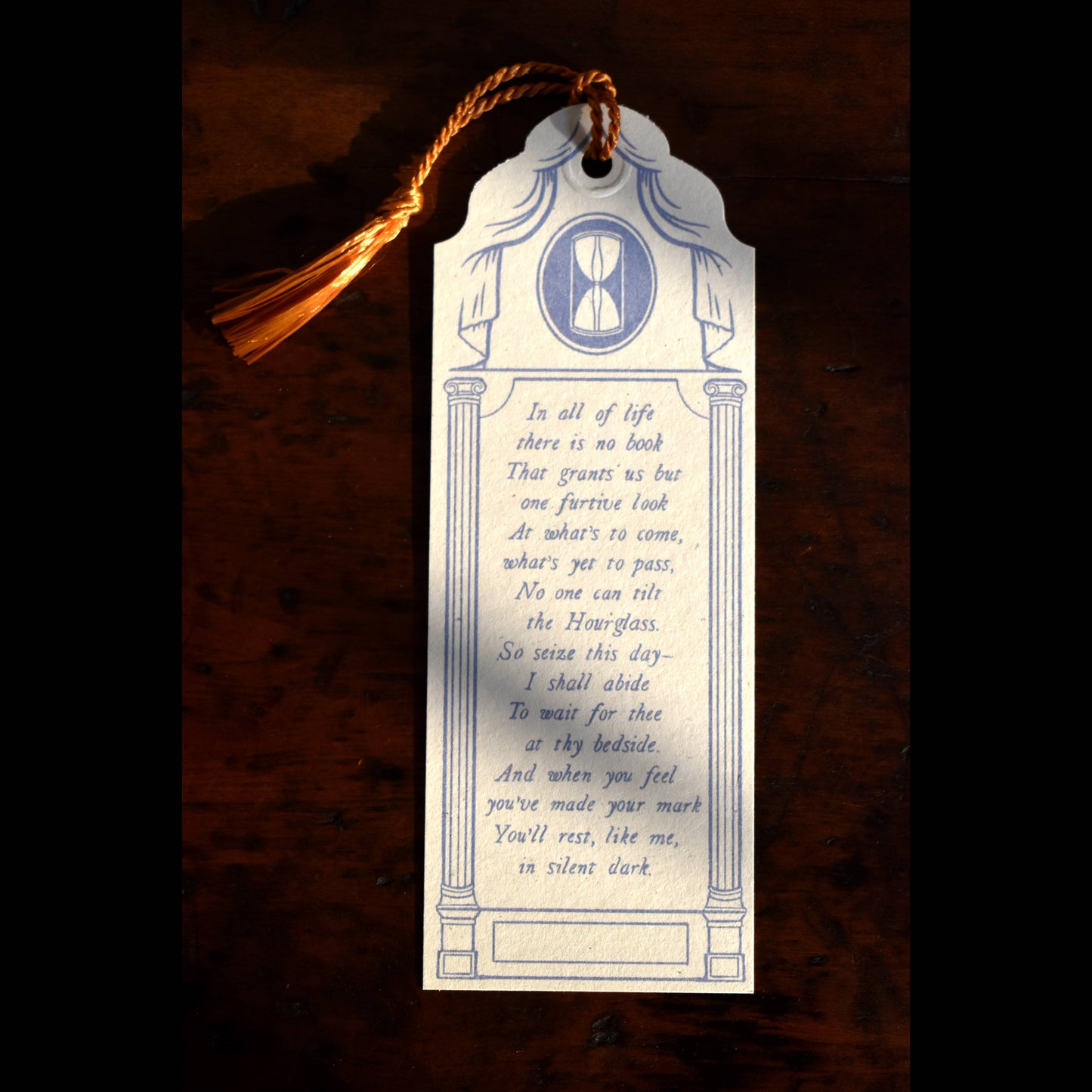 Decorative bookmark with text and design on a wooden surface