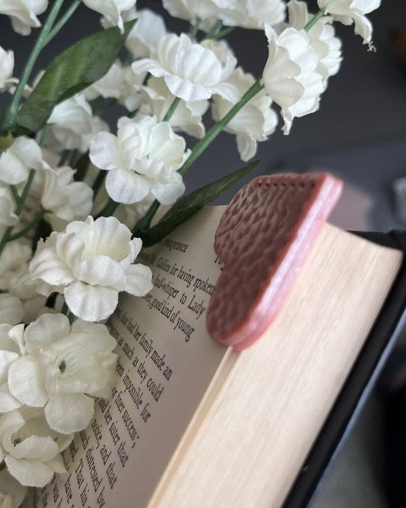 White flowers on an open book with a textured object on top