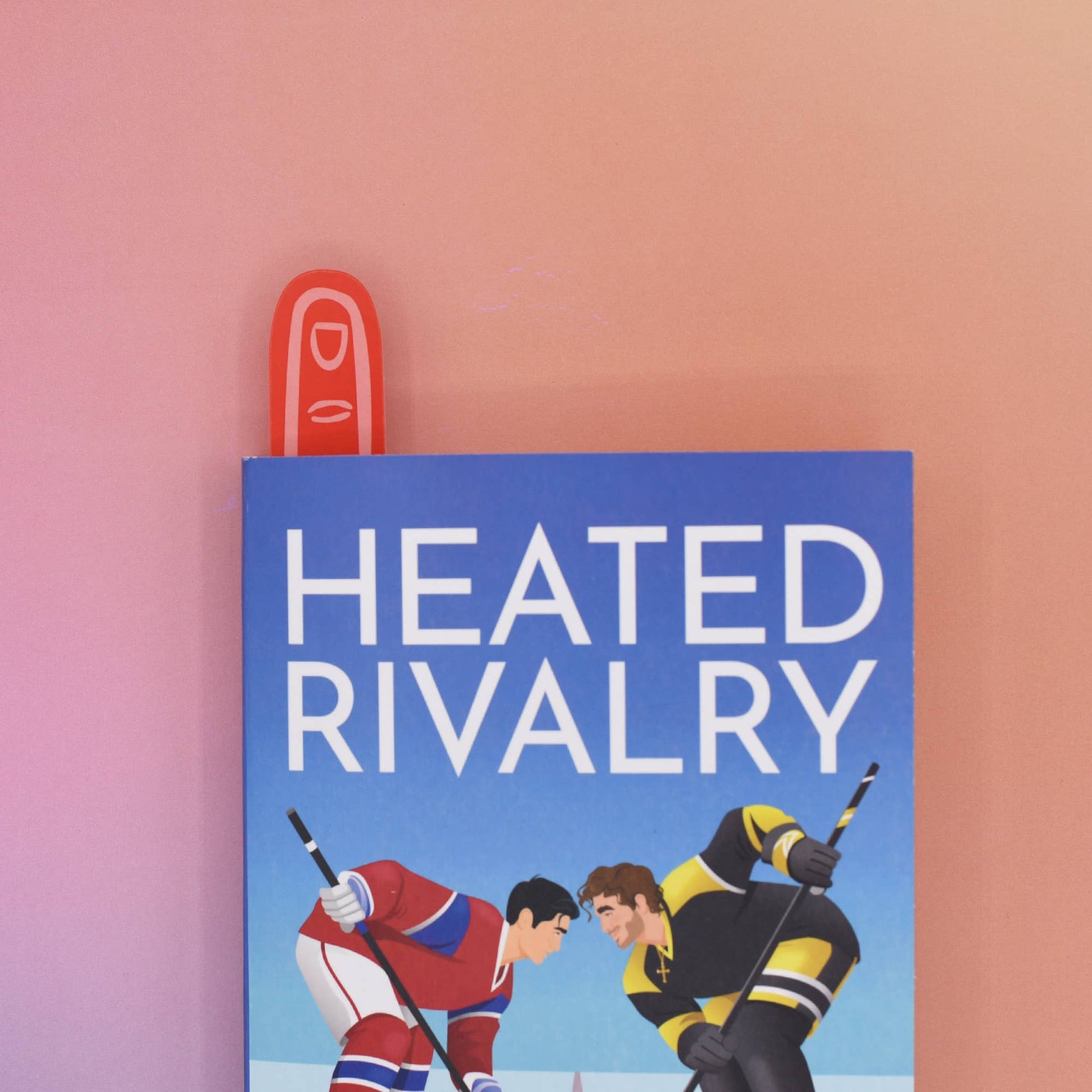 Book cover of 'Heated Rivalry' with two hockey players on a blue background